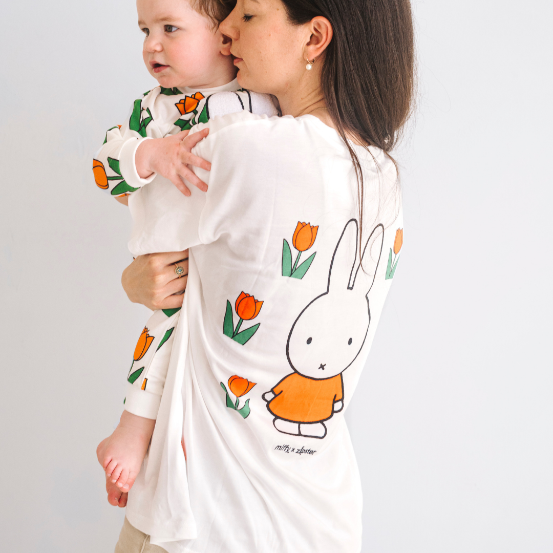 Mujer con la camiseta blanca de lactancia Miffy, con un tulipán bordado y cremalleras para la lactancia