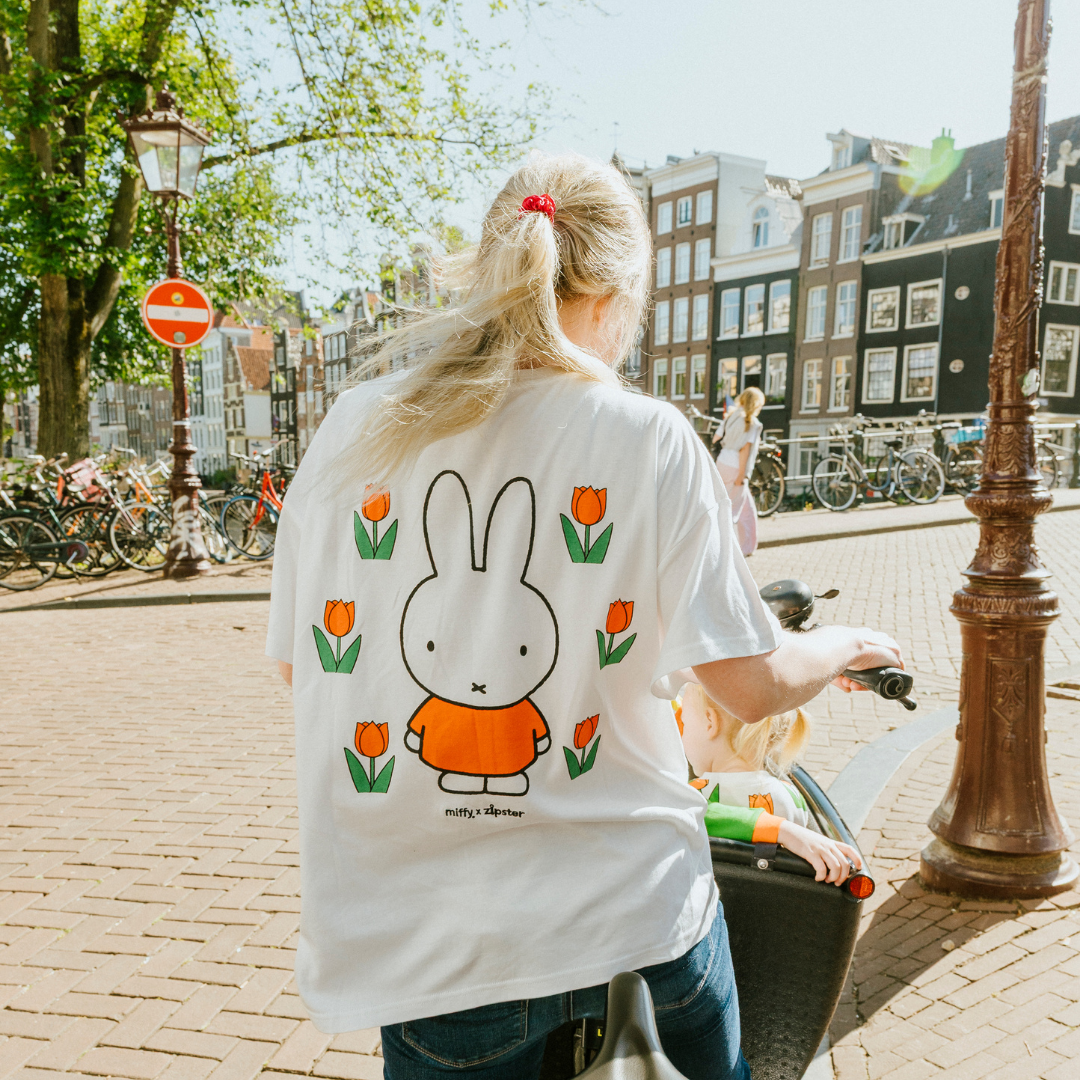 Mujer con la camiseta blanca de lactancia Miffy, con un tulipán bordado y cremalleras para la lactancia